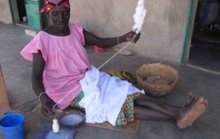 Alte Frau beim Spinnen